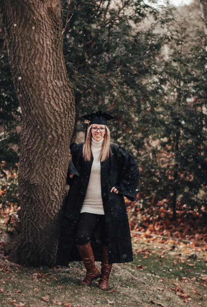 A smiling woman in a gown and cap for graduation